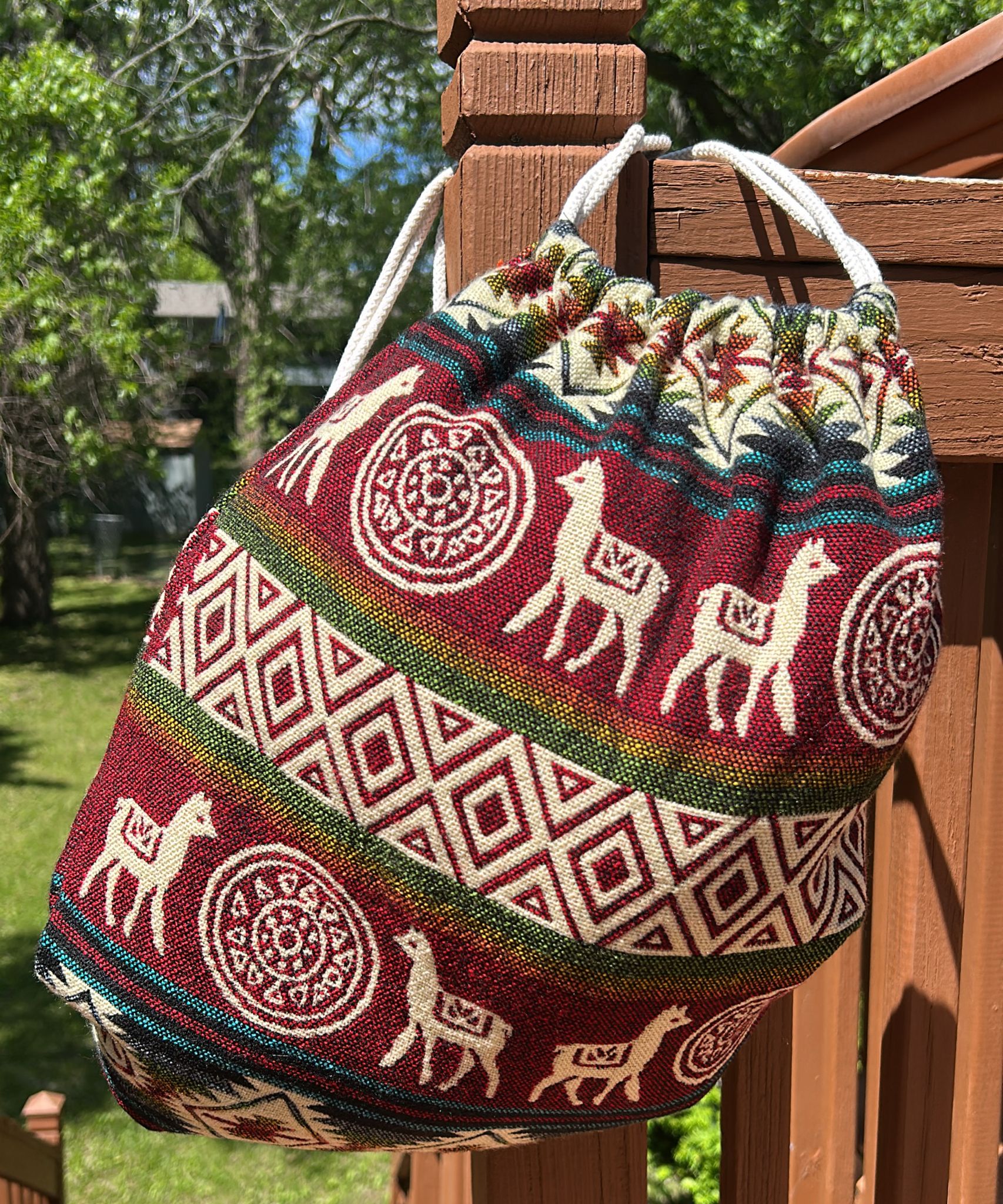 Drawstring backpack-style bag, handwoven in native Andean style with llama motifs.