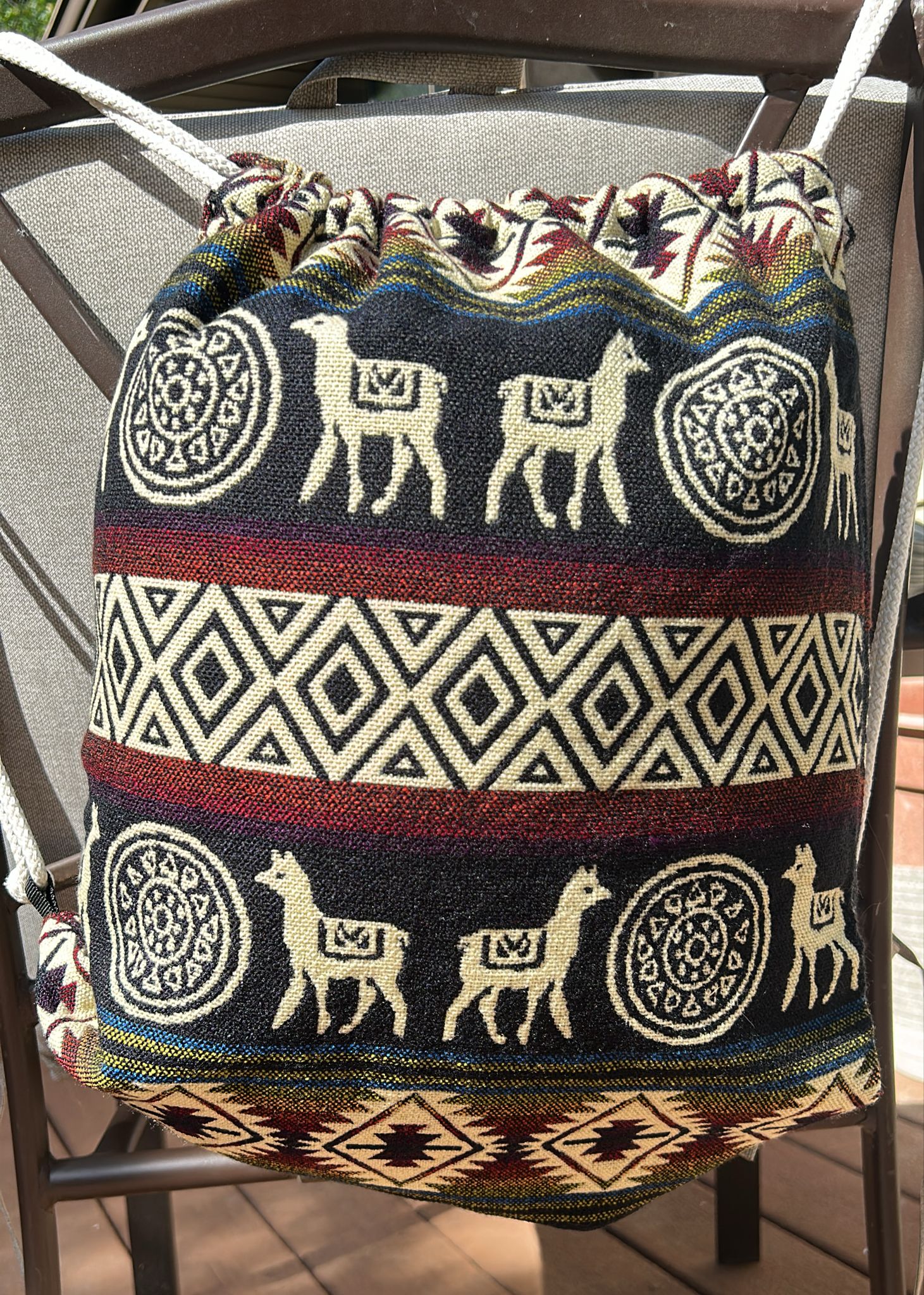 Drawstring backpack-style bag, handwoven in native Andean style with llama motifs.
