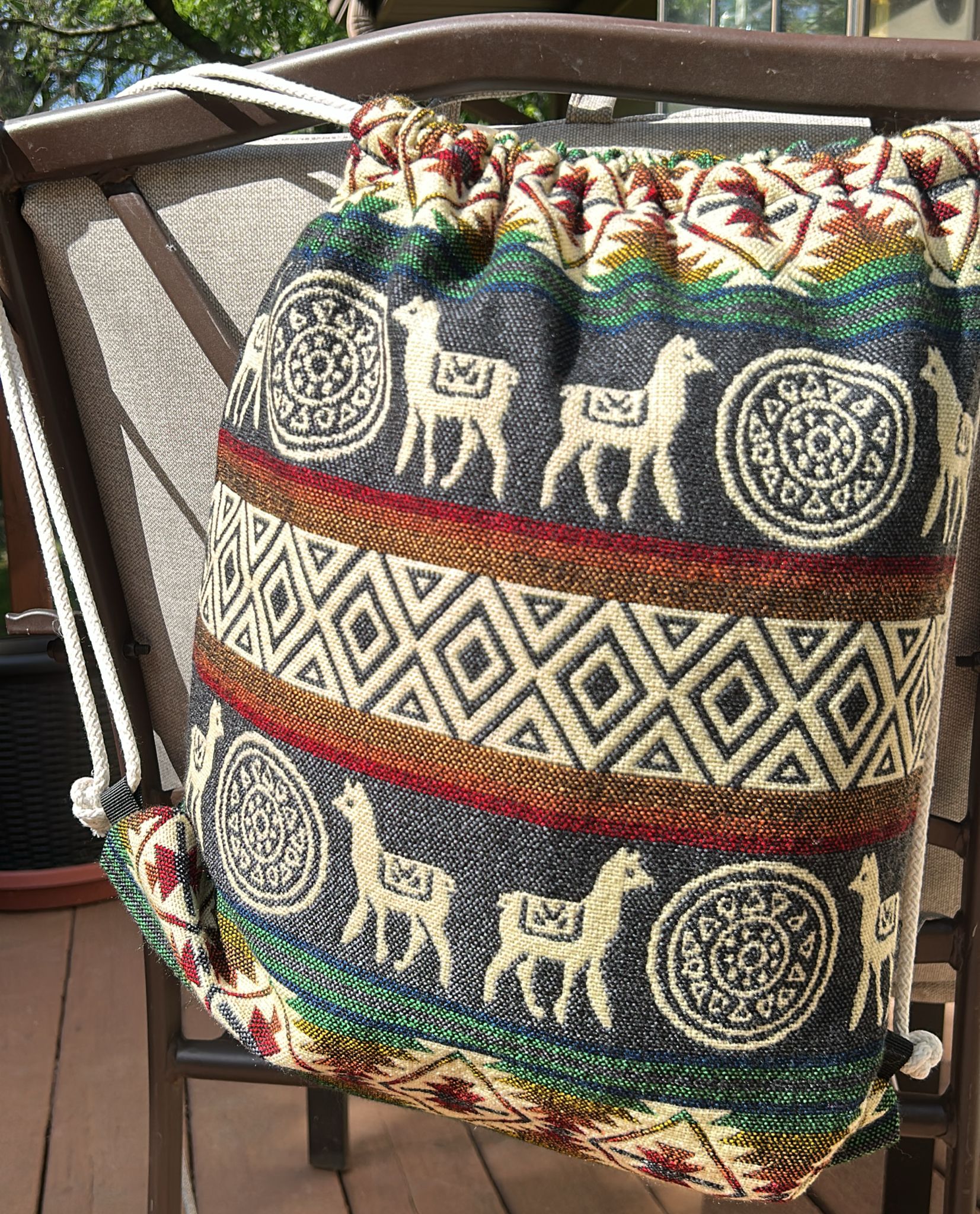 Drawstring backpack-style bag, handwoven in native Andean style with llama motifs.