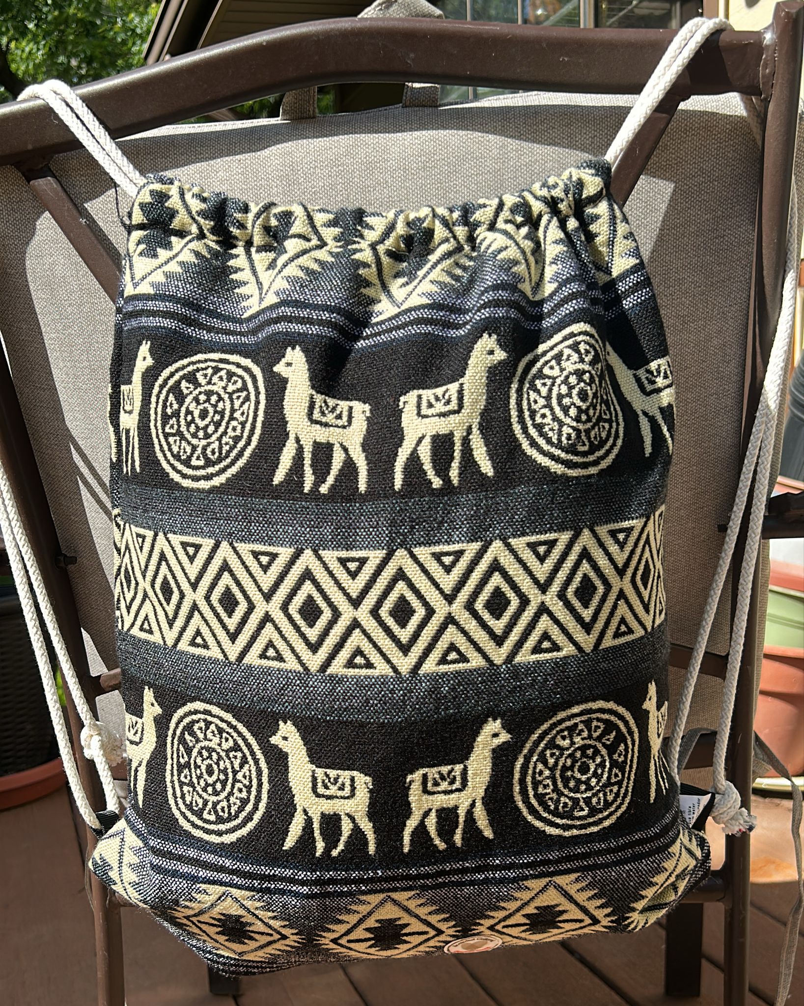 Drawstring backpack-style bag, handwoven in native Andean style with llama motifs.
